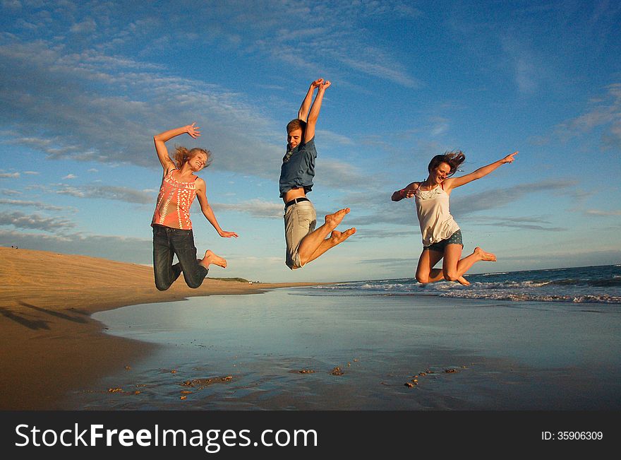 Teenagers leap high into the air at an unspoiled beach in South Africa. Teenagers leap high into the air at an unspoiled beach in South Africa.