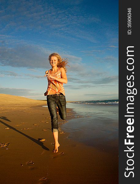 A young blonde girl runs barefoot on the beach at Sardinia Bay in Port Elizabeth, South Africa. A young blonde girl runs barefoot on the beach at Sardinia Bay in Port Elizabeth, South Africa.