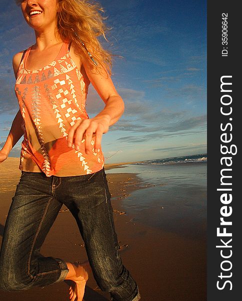 A close up of a smiling young girl running past barefoot on the beach. A close up of a smiling young girl running past barefoot on the beach.