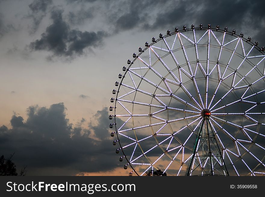 Ferris wheel with light decoration against the dark sky. Ferris wheel with light decoration against the dark sky