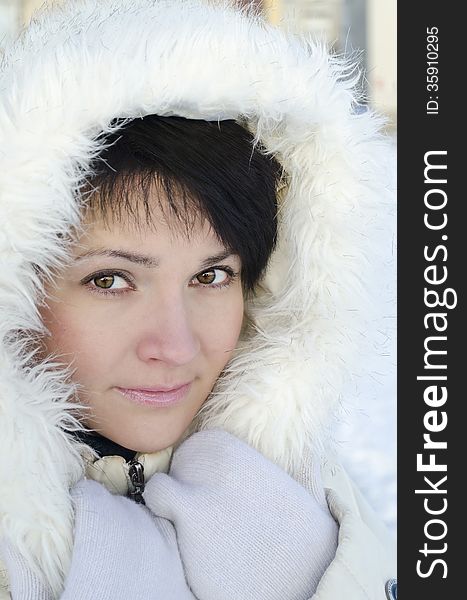 Beautiful winter portrait of young woman in the winter snowy