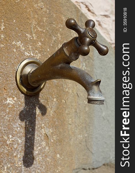 Old brass faucet on the wall