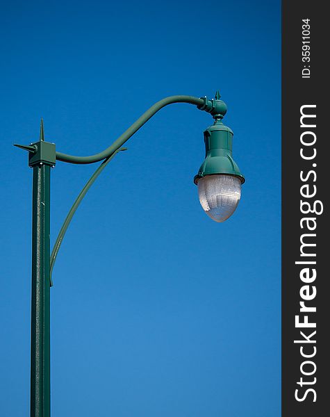 A nice and elegant streetlamp isolated against a clear blue sky.