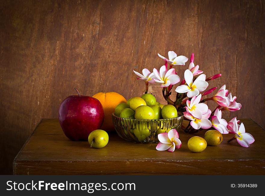 Plumeria flower and many fruit on old wood table