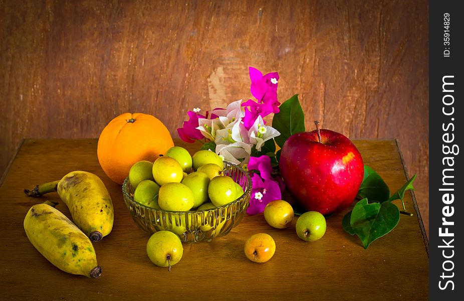 Fresh Bougainvillea flower and many fruit on old wood table ,still life