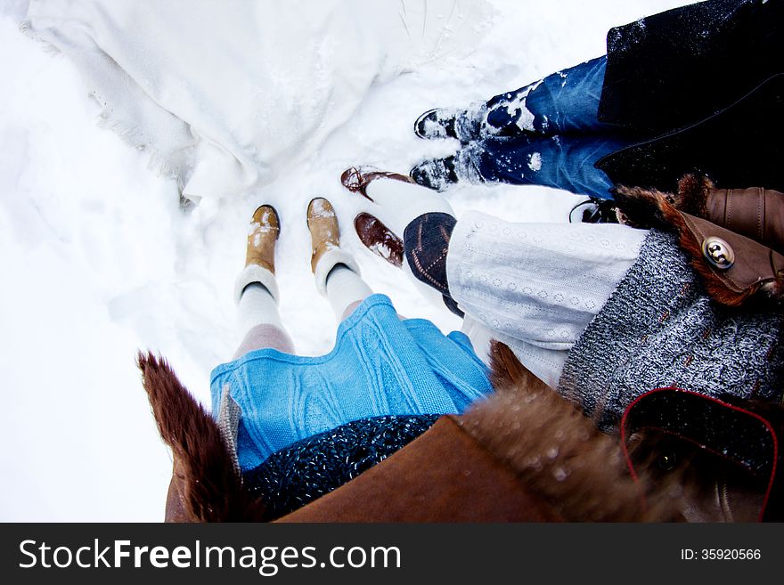 People&#x27;s legs on snow white winter background fisheye
