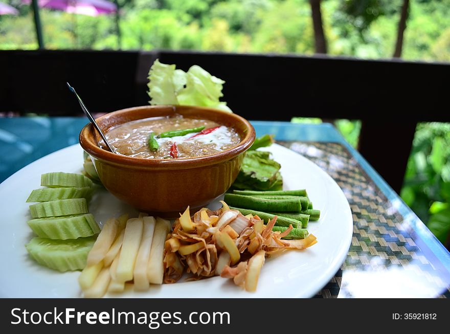 Thai food, fish with coconut milk sauce on white plate with vegetables