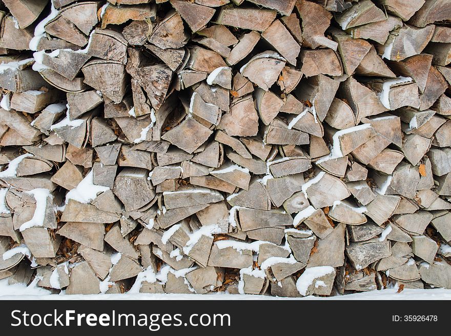 Newly felled timber. stack of wood under the snow