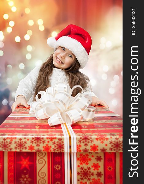 Child In Santa Hat With Gift Box.