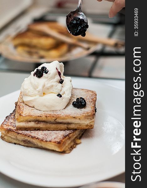 Decorating french toast with blueberry jam