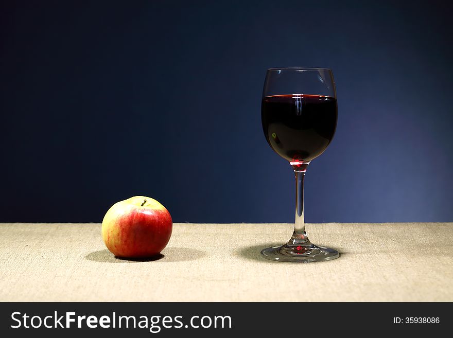 Still life with one goblet of red wine near apple. Still life with one goblet of red wine near apple