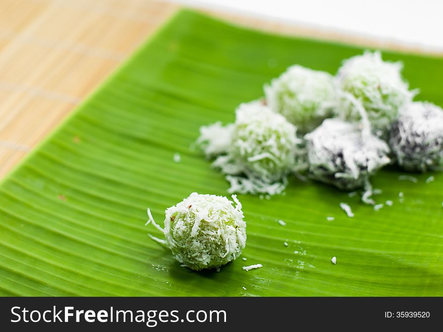 Thai dessert sweet boiled ball , roll over the grated coconut on banana leaf