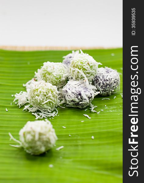 Thai dessert sweet boiled ball , roll over the grated coconut on banana leaf