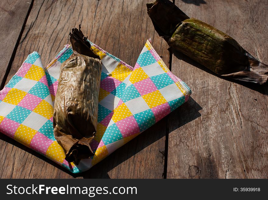 Delicious Thailand dessert, sticky rice toast with taro and banana leaf on wood background