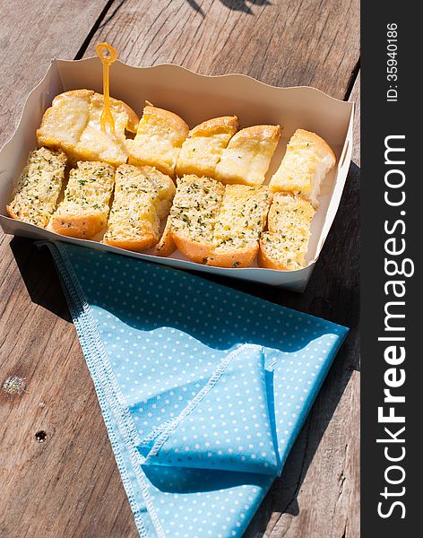 Fresh-baked garlic bread with herbs, on white bread tray