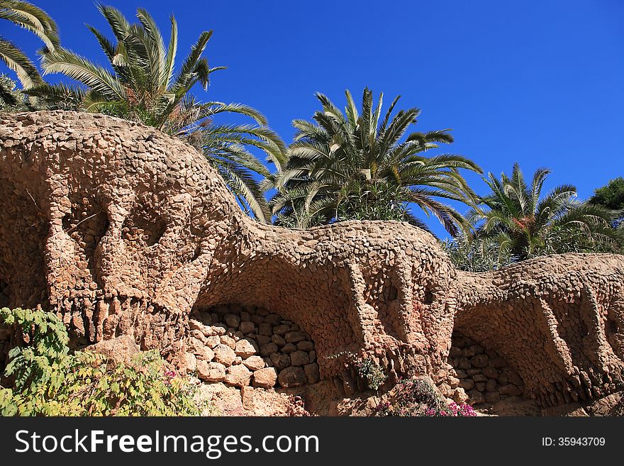 Palm trees on the nice wave wall in Park Guell. Barcelona, Spain