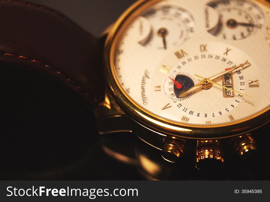 A close-up photo of golden colour luxury chronometer (macro). A close-up photo of golden colour luxury chronometer (macro)