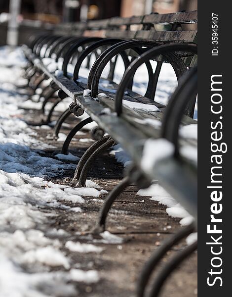 Row of benches in the snow at NYC park