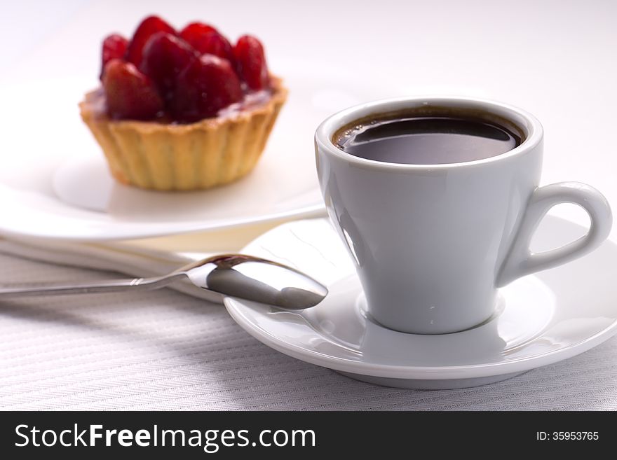 Whie Cup of Black Coffee with Strawberry Dessert in a Waffle Basket