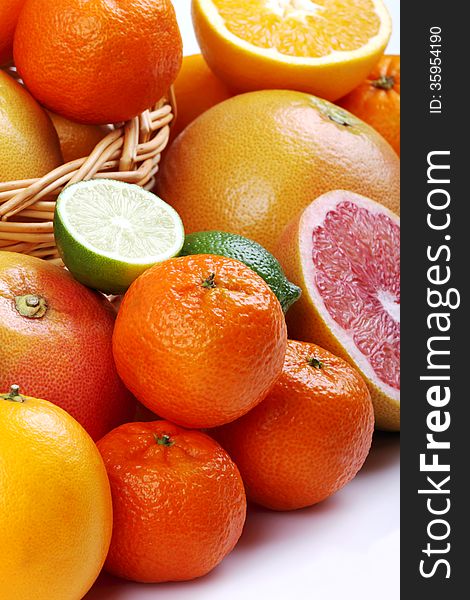 Wicker basket with various types of citrus fruits on white background. Wicker basket with various types of citrus fruits on white background