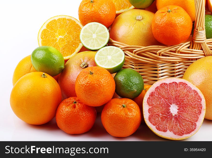 Wicker basket with various types of citrus fruits on white background. Wicker basket with various types of citrus fruits on white background