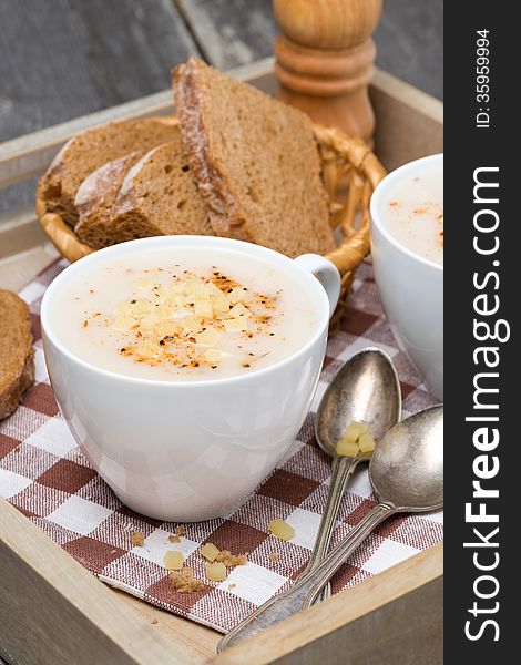 Delicious cream soup of cauliflower with cheese and pepper, vertical