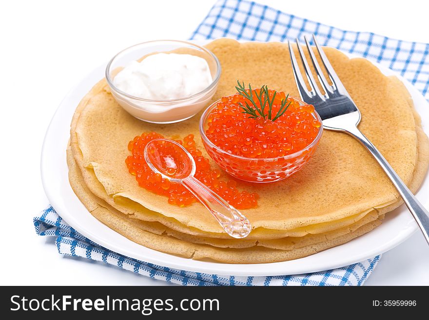 Delicious crepes with red caviar, dill and sour cream, isolated on white