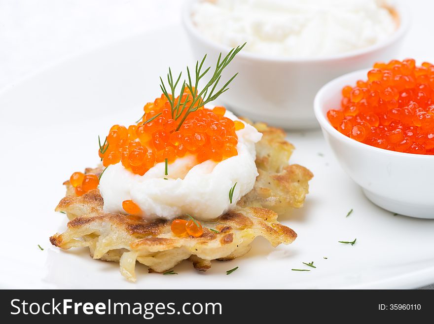 Potato pancakes with red caviar and sour cream, close-up, horizontal