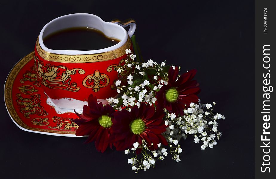 Cup of coffee and flowers on a black background