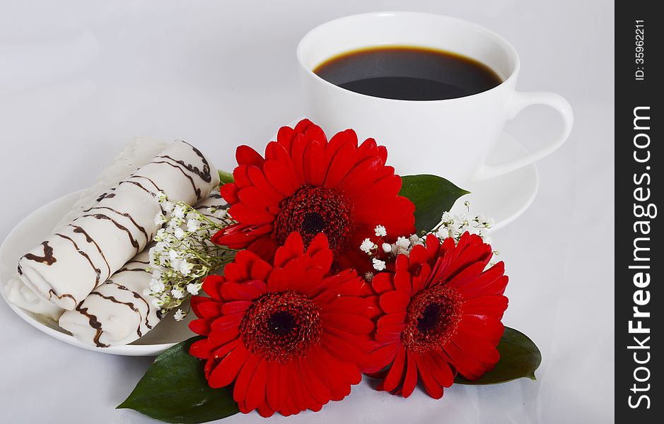 Cup of coffee, cookies and red flowers on a white background. Cup of coffee, cookies and red flowers on a white background