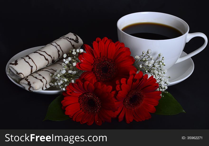 Cup of coffee, cookies and red flowers on a black background. Cup of coffee, cookies and red flowers on a black background