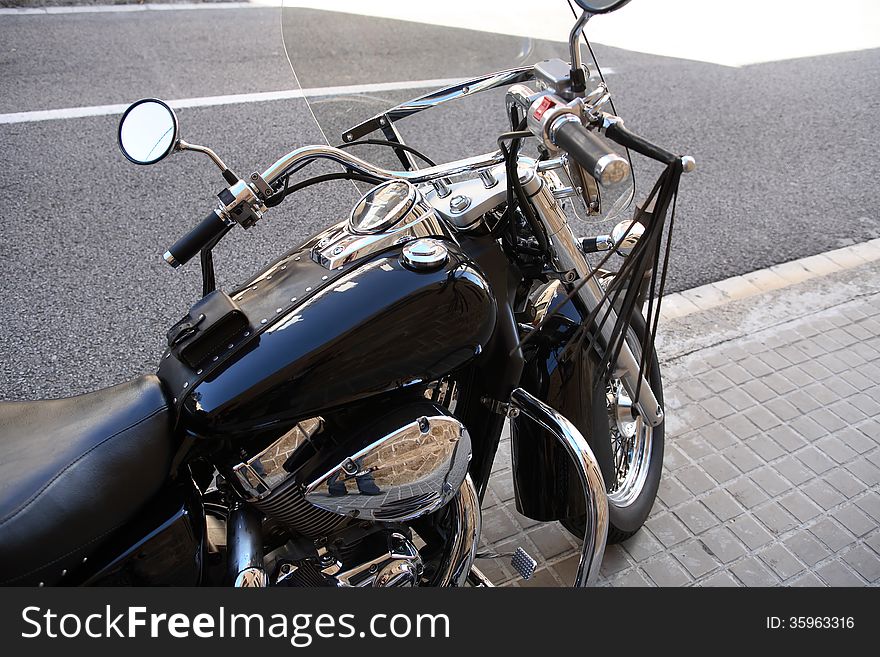 Urban transportation. Stylish black motorcycle on street in the town