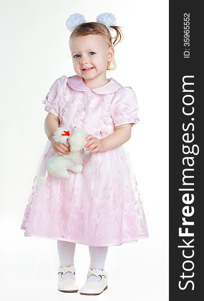 Little girl standing in full growth with toy and smiling