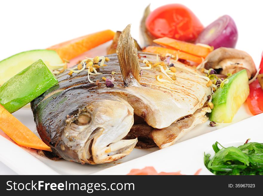 Fried wish with grilled vegetables and chukka seaweed, macro closeup