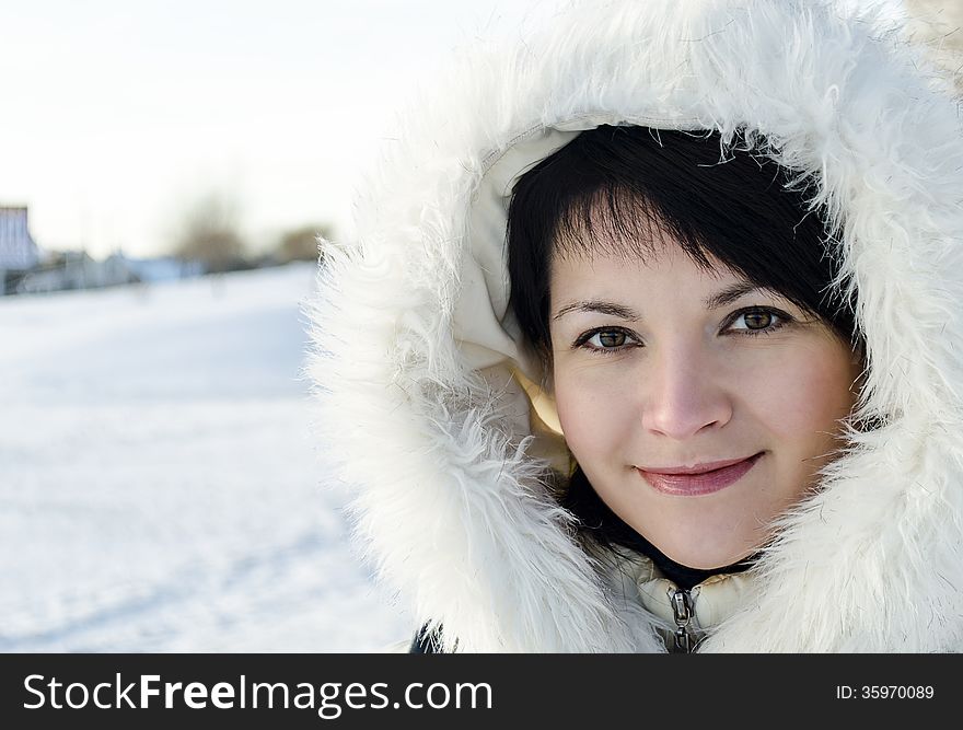 Beautiful winter portrait of young woman in the winter snowy