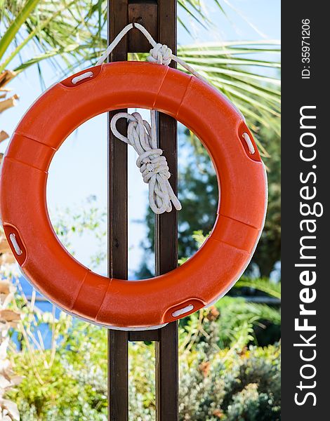 life buoy with rope hanging around the pool