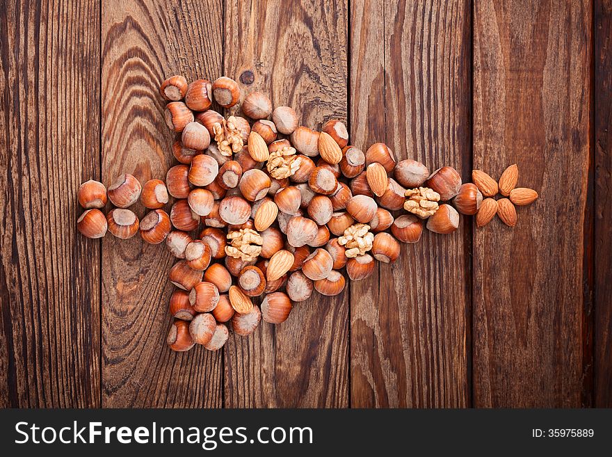 Hazelnuts, filbert on old wooden background. Christmas tree made of hazelnuts on a wooden surface