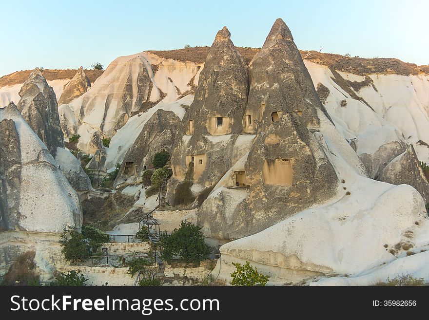 In ancient times people carved out homes in the fairy chimney rock formations in Cappadocia, Turkey. The houses are a popular tourist attraction for people on vacation or holiday. In ancient times people carved out homes in the fairy chimney rock formations in Cappadocia, Turkey. The houses are a popular tourist attraction for people on vacation or holiday.