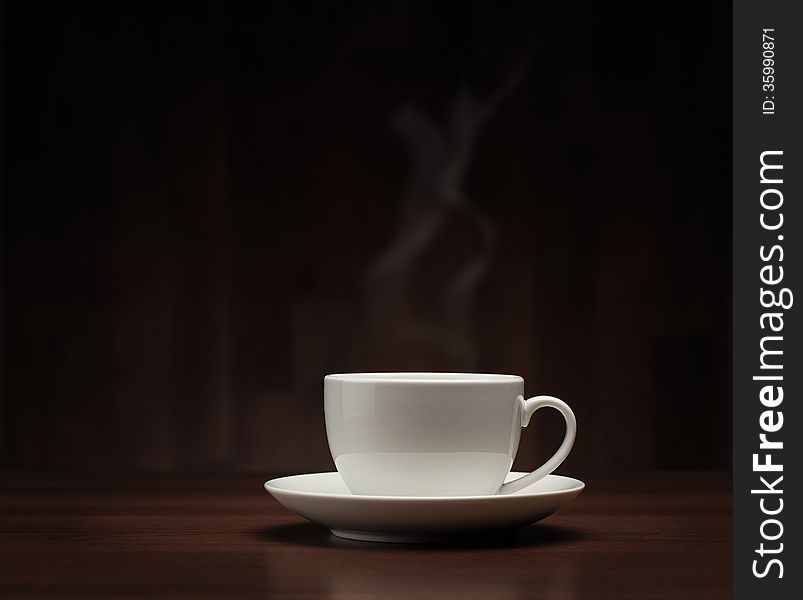 Close up of coffee cup on the table over dark background with copy space. Close up of coffee cup on the table over dark background with copy space