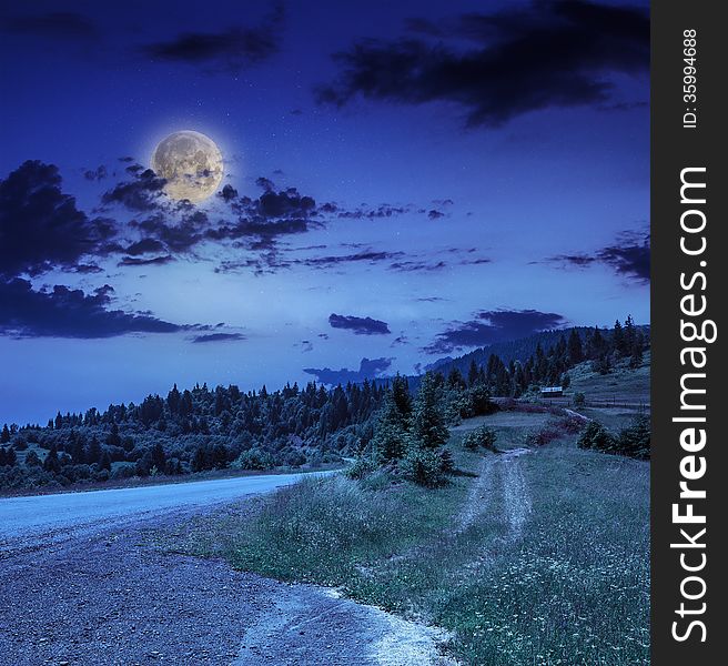 Empty asphalt mountain road with Painted single white Line near the coniferous forest with cloudy sky at night. Empty asphalt mountain road with Painted single white Line near the coniferous forest with cloudy sky at night