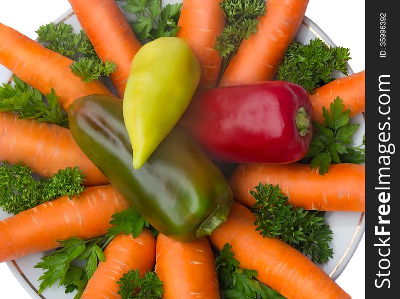 Carrot, onion and parsley on the plate on a white background.