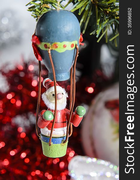 Small Santa Claus Christmas decoration fly under the tree to bring gifts.