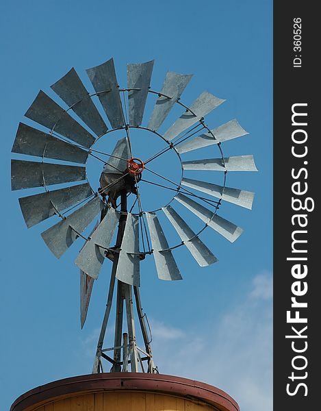 An old windmill sits idle against a blue sky full of wispy clouds. An old windmill sits idle against a blue sky full of wispy clouds.