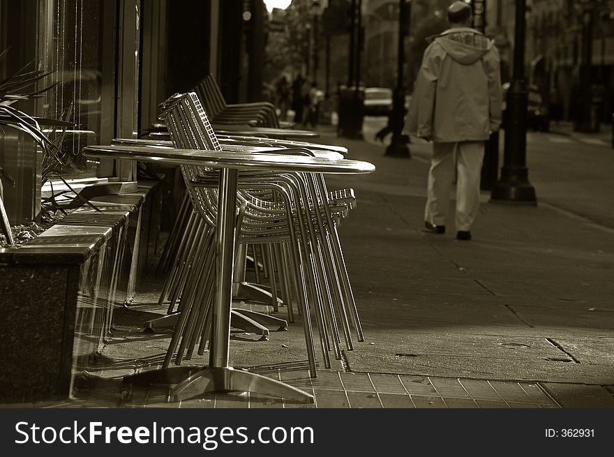 City living sepia driving by shaft of light chairs stacked up on an urban street. City living sepia driving by shaft of light chairs stacked up on an urban street