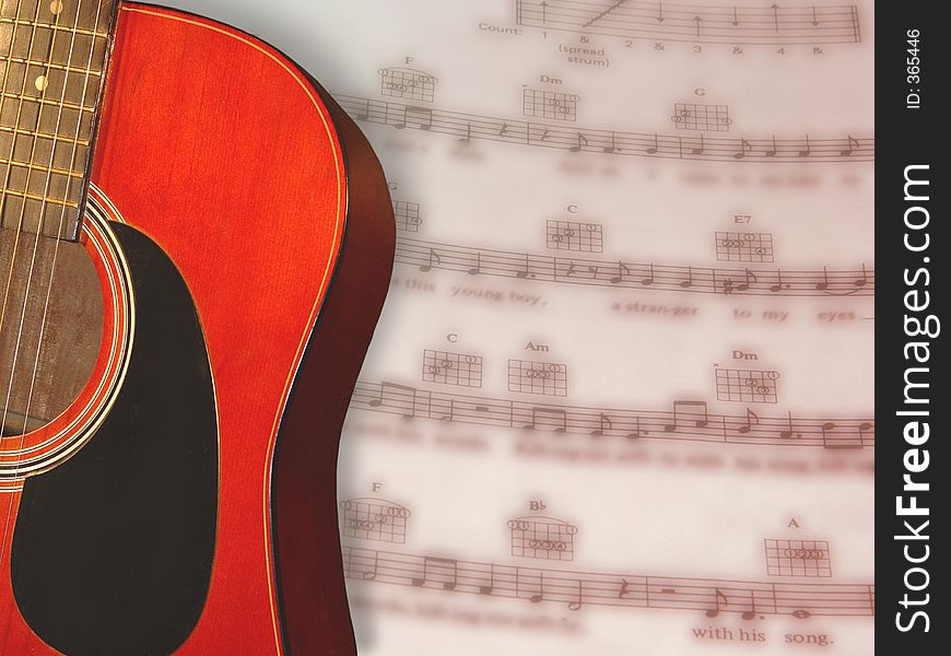 Acoustical guitar with its reddish toned wood against a blurred sheetmusic background. Acoustical guitar with its reddish toned wood against a blurred sheetmusic background.