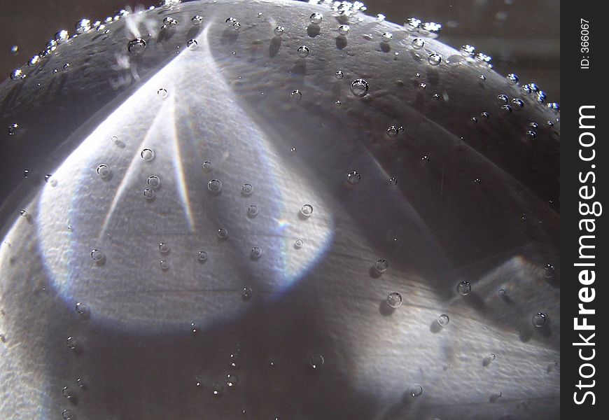 This photo was taken through glass and is an image of an egg submerged in soda water. This photo was taken through glass and is an image of an egg submerged in soda water.