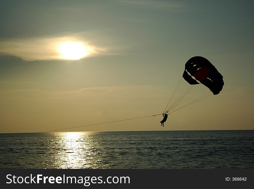 Silhoutte of parachuting by the sea