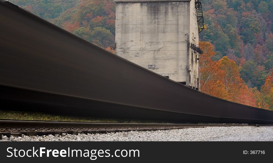 Locomotive passing through a valley painted by autumn leaves. Locomotive passing through a valley painted by autumn leaves.