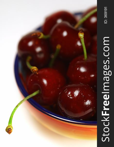 Ripe and juicy cherries in colorful bowl
