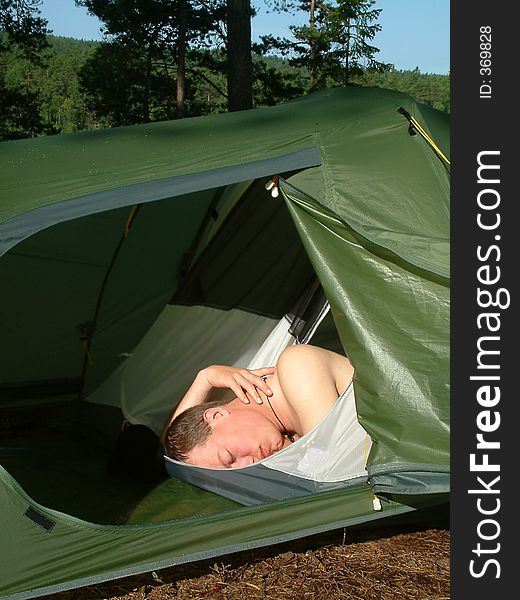 Man sleeping in a tent. Man sleeping in a tent.